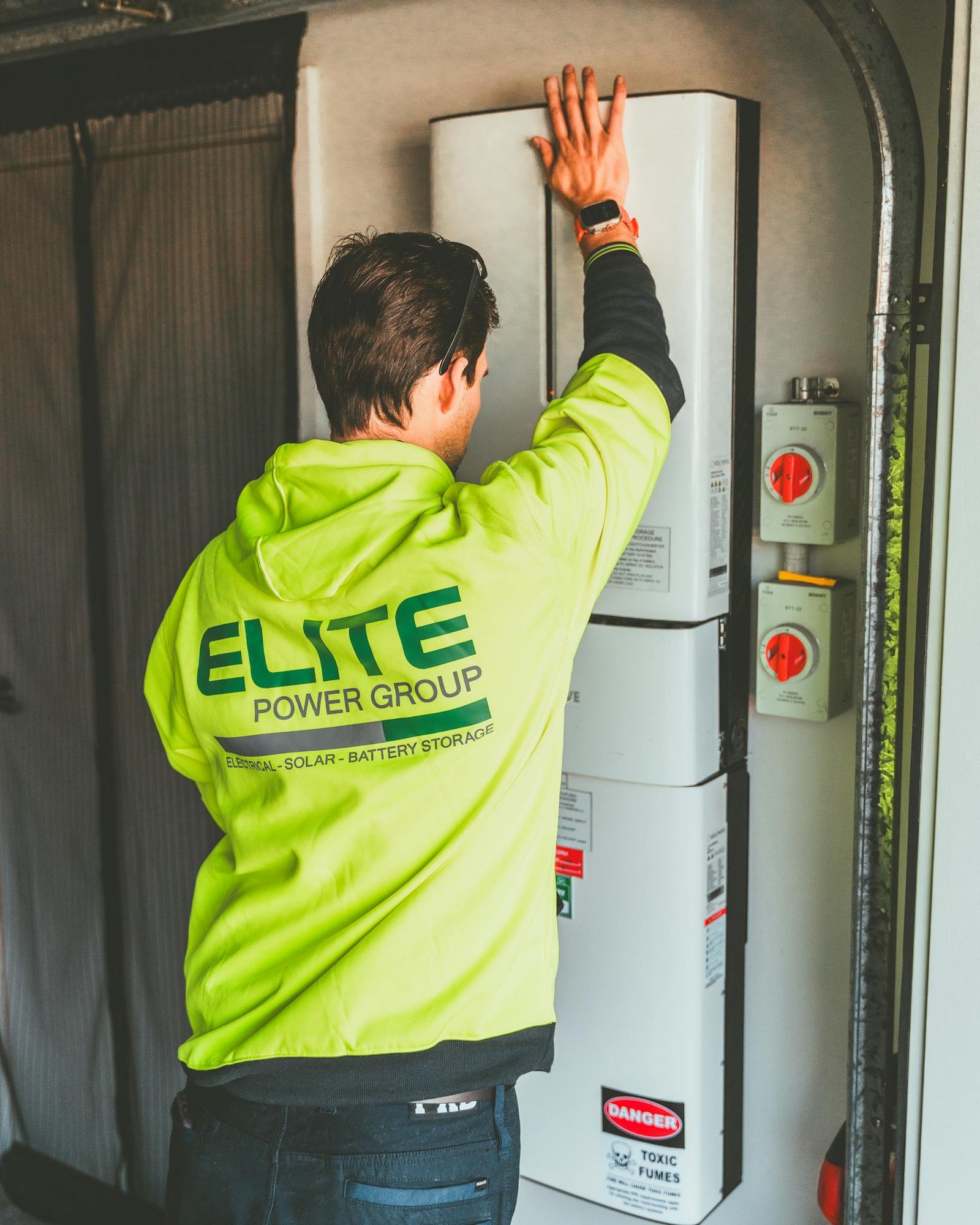 Technician installing a solar inverter and battery system in New South Wales.